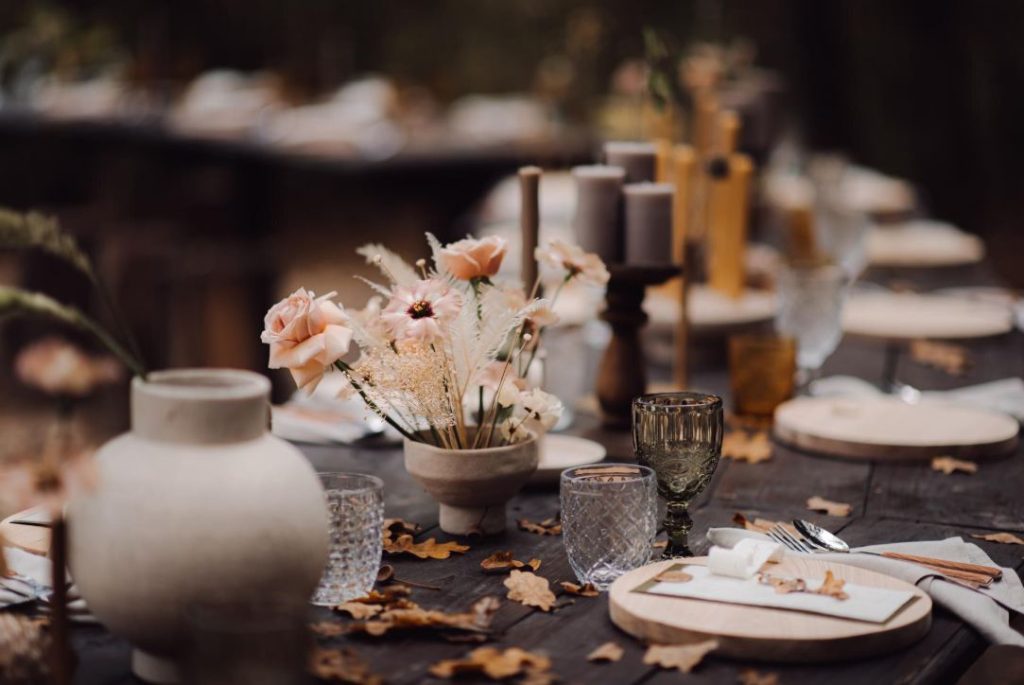 Table de banquet en bois brut ornée de céramiques et fleurs séchées selon les nouvelles tendances mariage deco et tenues.